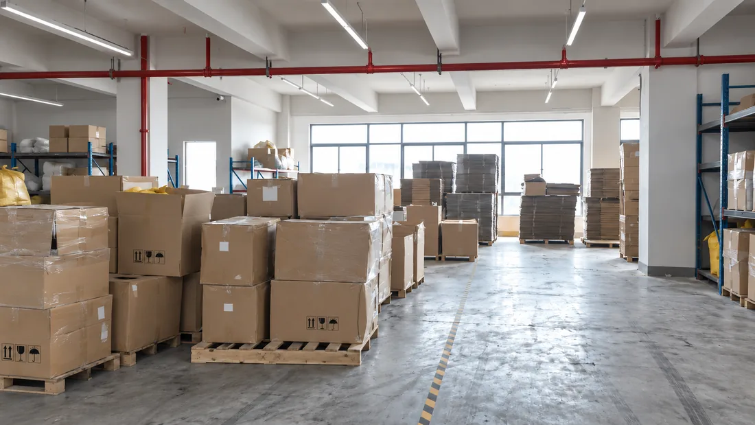Cartons on pallets along a warehouse aisle